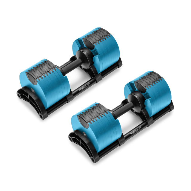 Two NÜOBELL Adjustable Dumbbells from Nuobell, featuring machined steel weight plates and blue accents, sit parallel. Their sleek, patent-pending design exhibits a visible weight adjustment mechanism. The "PROGLUX" logo adorns the center handle.