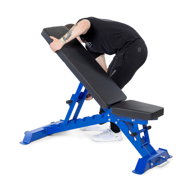 Dressed in black, a person adjusts the backrest of the Buzz-Saw Heavy-Duty Adjustable Bench by Bells of Steel, seamlessly incorporating it into their fitness routine.