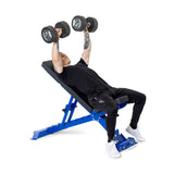 A person in black attire and white sneakers performs a bench press on the Buzz-Saw Heavy-Duty Adjustable Bench by Bells of Steel, lifting dumbbells above their chest during their workout.