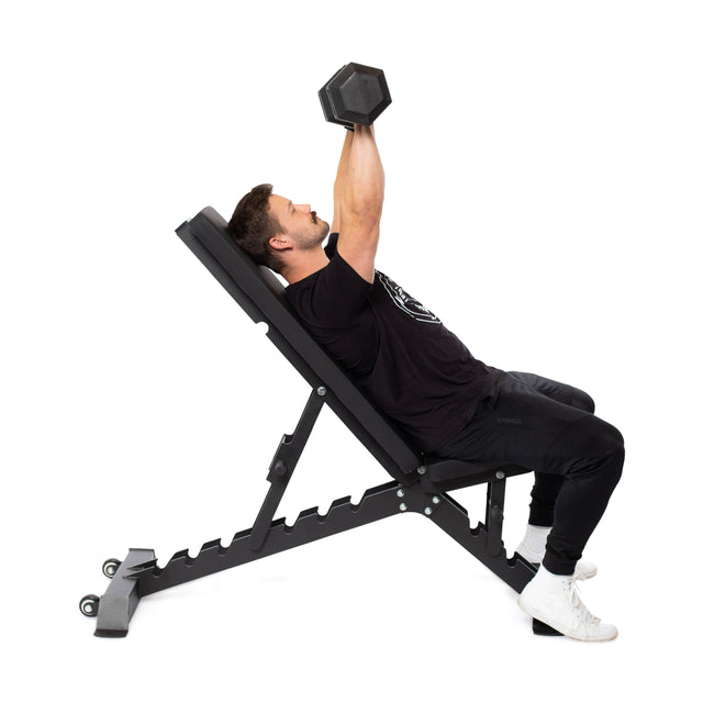 Wearing a black shirt and pants, an individual performs an incline bench press with dumbbells on the Bells of Steel Buzz-Saw Heavy-Duty Adjustable Bench, which boasts a 1,000lb max capacity.