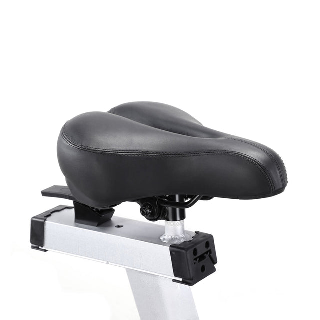 Close-up of a black, contoured, cushioned bicycle seat with an ergonomic design, mounted on the gray frame of the Bells of Steel Blitz Air Bike. Set against a plain white background, this seat is ideal for elevating your home gym experience.