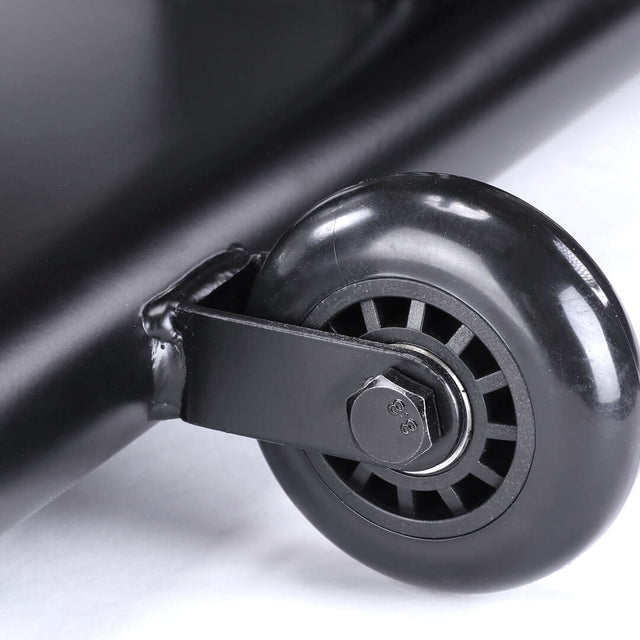 Close-up of a black caster wheel on the sleek bracket of a Bells of Steel Blitz Air Bike, resting on a smooth, light-colored surface, ready to roll into action for intense full-body workout sessions.