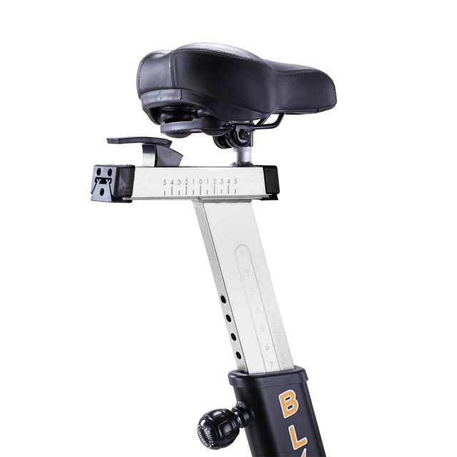 Close-up of the adjustable bicycle saddle on the Bells of Steel Blitz Air Bike: a black seat on a metal rail with a height scale, attached to a black frame with knobs for adjusting height and position—ideal for your home gym and full-body workouts.