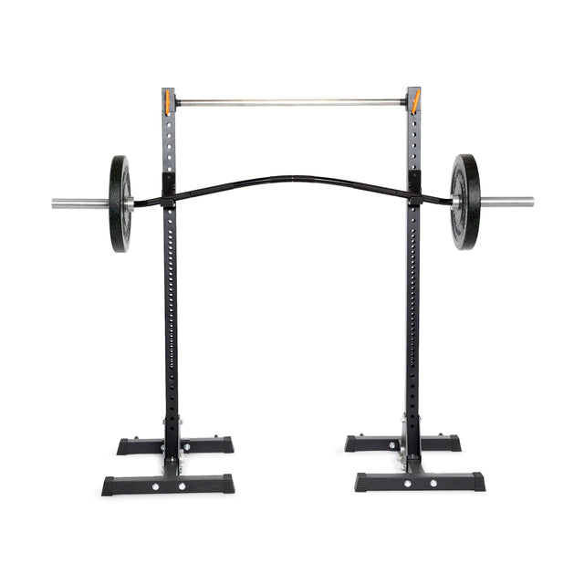 A Bells of Steel Curved Squat Bar setup with a black squat rack, adjustable safety bars, and weight holders on a white background is designed to alleviate joint stress during workouts.