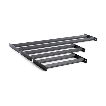 The Bumper Plate Pins Shelf by Bells of Steel features four black metal wall brackets, each with a simple rectangular shape and end holes for easy mounting, perfect for supporting shelves or similar fixtures to efficiently and stylishly organize your space.