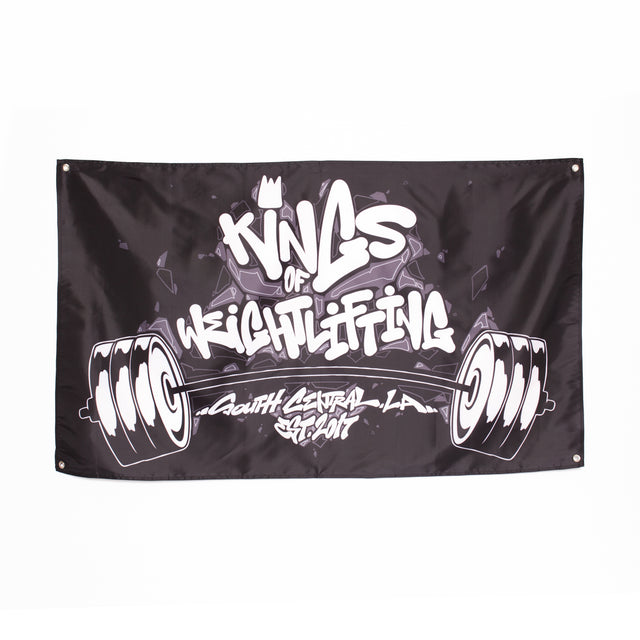 A black Bells of Steel flag with the phrase "Kings of Weightlifting, South Central L.A." in bold white graffiti-style font is an excellent gym decor choice. This home gym banner includes a barbell illustration with weights on each side, making it perfect for any workout space.