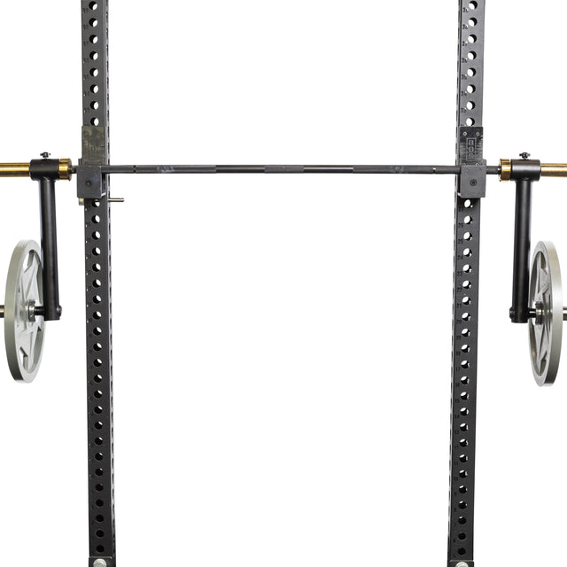 A close-up of gym equipment showcases a Bells of Steel power rack with adjustable black supports. Two large silver wheels are prominent beside the Camber Bar Attachment - Pair from Bells of Steel. The rack includes barbell collars for security and multiple holes for height adjustments.