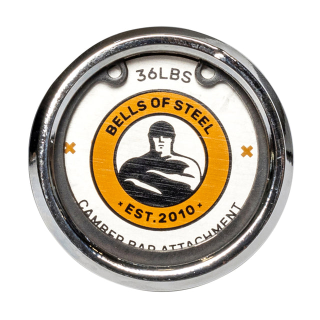 A close-up of a circular metal attachment for camber bars features the logo of Bells of Steel, with a stylized figure and the words "Est. 2010" in the center. The top displays "36 lbs." Silver edges stand out against an orange-and-white background, designed to enhance stabilizer muscles during lifts.