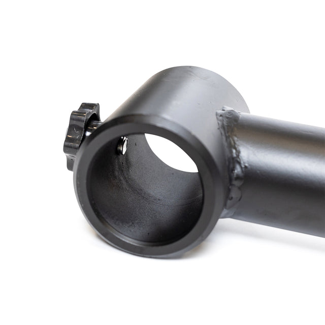 Close-up of a black metal cylindrical object resembling the Camber Bar Attachment - Pair from Bells of Steel, featuring a large tube opening and a smaller side knob. The sturdy material has a matte finish with visible weld marks along the connection, positioned against a white background and suggesting enhanced stabilizer muscle engagement.