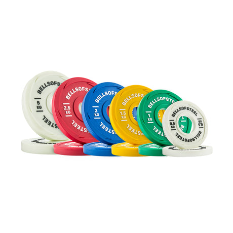 A set of Bells of Steel Urethane-Coated Change Plate Sets in white, red, blue, yellow, and green, each labeled with kilogram weights and arranged upright on a white background for added durability.