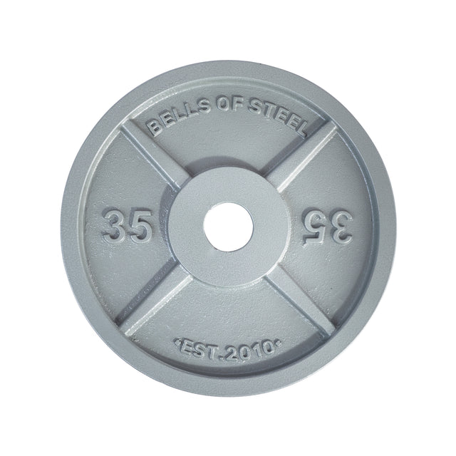 The Machined Iron Olympic Weight Plates from Bells of Steel are round and gray with "BELLS OF STEEL" and "EST. 2010" beautifully engraved at the top and bottom. These plates offer a precision hole fit, with the number "35" displayed on each side of the central opening, combining functionality with a sleek design.