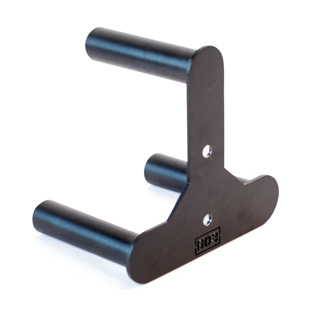 The Bells of Steel Change Plate Storage Pegs is a black metal wall-mounted guitar hanger with storage pegs, featuring two cylindrical arms and a flat mounting plate with screw holes. It has a matte finish and includes a small logo on the plate.