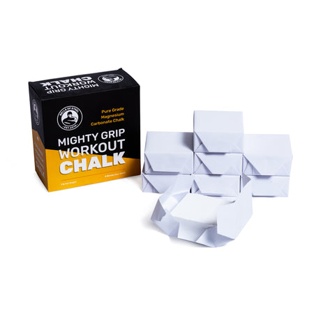 A box labeled "Bells of Steel Mighty Grip Workout Chalk" sits beside several individually wrapped, pure-grade chalk blocks neatly stacked in front of it on a white background.