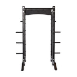 The Bells of Steel Hydra Collegiate Power Rack Builder (3" x 3", ⅝" Holes) is a black metal power rack with modular components, featuring multiple adjustable holes and safety bars for weightlifting. It includes side pegs for weight plate storage, has a sturdy base for stability, and can be enhanced with Hydra Lat Pulldown attachments.