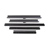 Six black metal brackets are arranged in two rows on a white surface, featuring screw holes—perfect for securing the Bells of Steel Commercial Interchangeable Weight Rack for urethane dumbbells or competition kettlebells.