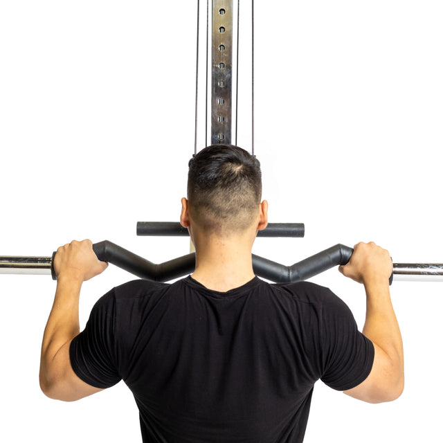 A person in a black shirt is seen from behind using the Fat Bar - Olympic Curl Bar Cable Attachment by Bells of Steel. Set against a white background, they grip the bar firmly with both hands to enhance grip strength during the exercise.