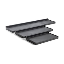 The Bells of Steel Dumbbell/Kettlebell Shelf features four black, rectangular metal shelves with raised edges and visible mounting holes, ideal for displaying collections or storing gear. These wall-mounted shelves are shown in a staggered arrangement for versatile functionality.