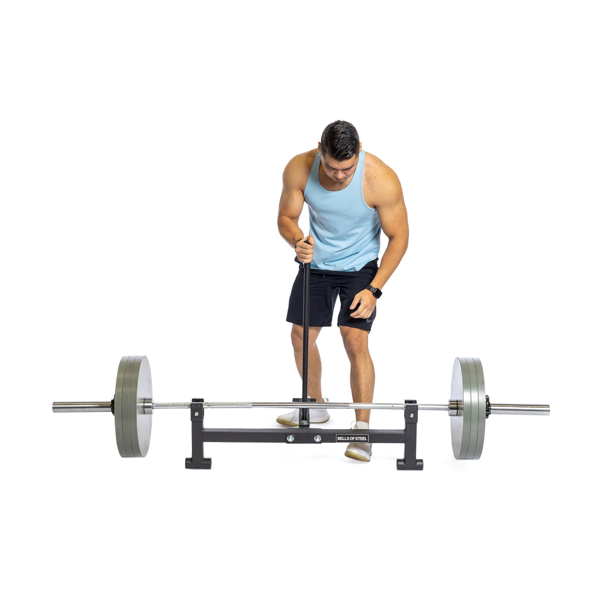 A person in a light blue tank top and black shorts uses the Bells of Steel Deadlift Jack with heavy-duty nylon rollers to lift a barbell with an 800lb capacity, set against a plain white background.