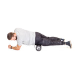 A man in a gray t-shirt and black pants uses the Bells of Steel Foam Roller under his right thigh while lying on his side, supporting himself on his forearms and left leg for effective self-myofascial release.