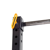 A close-up of the Bells of Steel Folding Rack 2.3" x 2.3" (5/8" Holes) shows its black metal frame with multiple adjustment holes, an orange safety pin, and a silver pull-up bar, set against a white background.