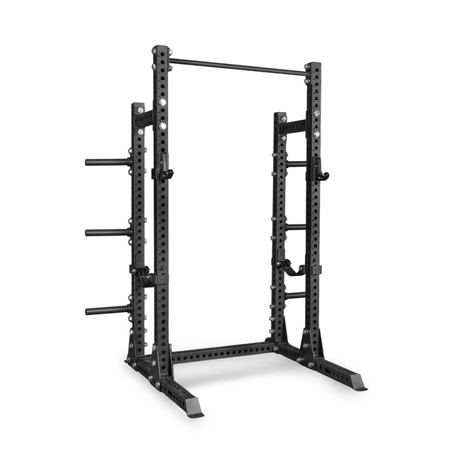 The Bells of Steel Manticore Half Rack - Prebuilt (3" x 3", 1" Holes) is a black metal half rack featuring 3x3 uprights, adjustable safety bars, pull-up bar, and weight plate storage pegs—designed for weightlifting and strength training exercises in your home gym.