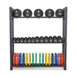 The Bells of Steel Hydra Storage Builder neatly organizes the 10-pound medicine balls on the top shelf, black dumbbells in the middle tier, and vibrant blue, yellow, green, and red weight plates on the bottom shelf—perfect for a home gym.