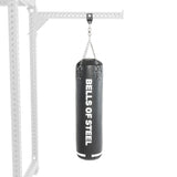 The durable black punching bag from the Heavy Bag Set hangs from a sturdy metal frame, ideal for combat sports training. It features "Bells of Steel" in bold white text on a plain background.