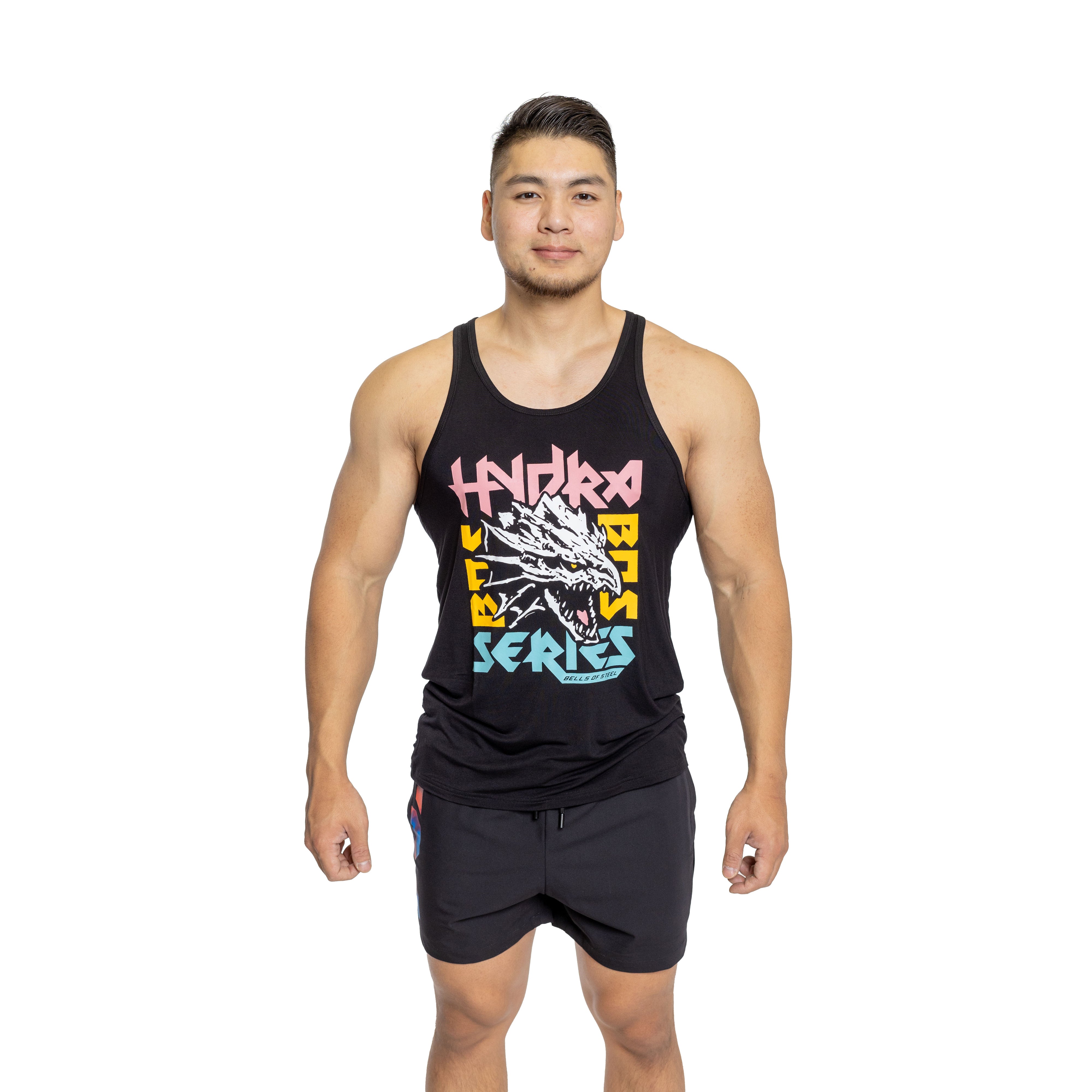 A man stands facing forward, wearing a buttery soft black Bamboo Tank Top featuring a colorful dragon design and the words "Hydra Bot Series." His black shorts complement the look as he maintains a neutral expression against a white background, embodying Bells of Steel's blend of style and sustainability.