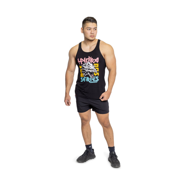 A person confidently poses in a buttery soft Bamboo Tank Top by Bells of Steel, featuring colorful graphics and paired with black shorts against a white background. Embracing sustainable style, their hands rest by their sides as they wear sleek black shoes.