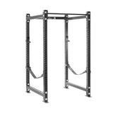 The Bells of Steel Hydra Four Post Power Rack Builder, featuring a 3" x 3" frame with ⅝" holes, comes equipped with a pull-up bar and Hydra Attachments. This power rack includes safety straps and is perfect for weightlifting and strength training exercises due to its perforated design that accommodates modular components.