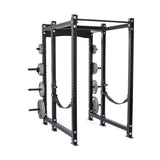 A black Bells of Steel Hydra Six Post Power Rack Builder (3" x 3", ⅝" holes) offers a 1,000-pound capacity with multiple weight plates and safety straps. Its numerous holes allow for adjustable positioning, ideal for various strength training exercises.