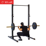 A person in black workout clothes uses the Bells of Steel Hydra Squat Stand Builder (3" x 3", ⅝" Holes) for squats. A red "10% off" banner appears in the top left. The clean white background suits any home gym.