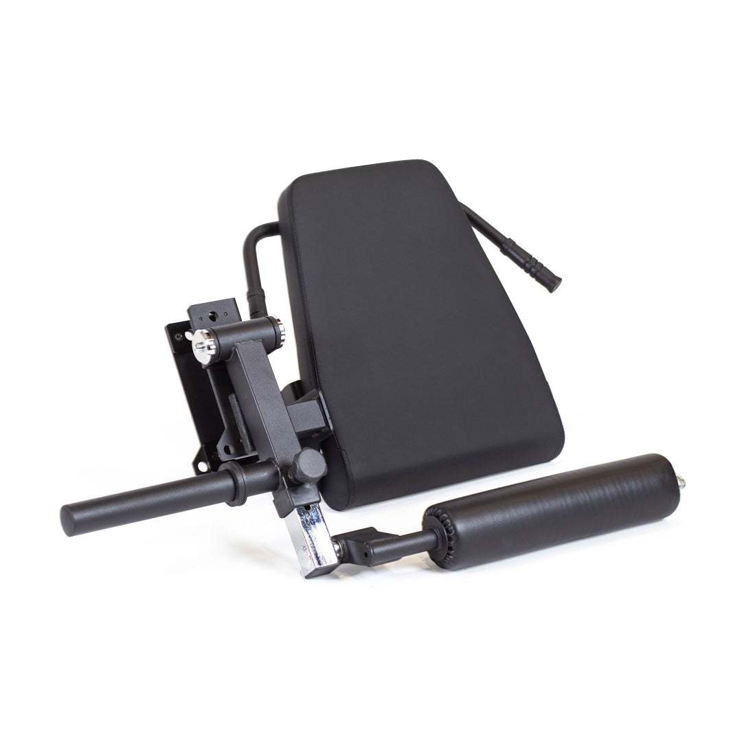 The Leg Curl / Leg Extension Rack Attachment by Bells of Steel is a black padded accessory featuring a rectangular backrest and cylindrical cushion, specifically designed to support and stabilize the body during workouts. Perfect for a home gym, it incorporates metal components and levers for adjusting positions, making it an ideal power rack attachment for leg extensions or curls.