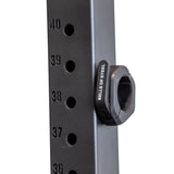 Close-up of a black gym rack upright with numbered holes (36–40) along the side. A Bells of Steel Magnetic Clamp Collar is secured in hole 38.