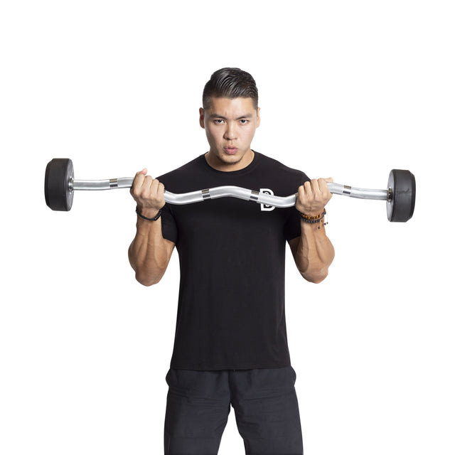 A person wearing a black t-shirt is lifting Bells of Steel's Fixed Barbells - Easy Curl with both hands, highlighting their home gym setup against a plain white background.