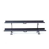 Two black, rectangular metal shelves from the Bells of Steel Commercial Interchangeable Weight Rack (Components Only) are stacked horizontally and supported by metal brackets, ideal for storing competition kettlebells.