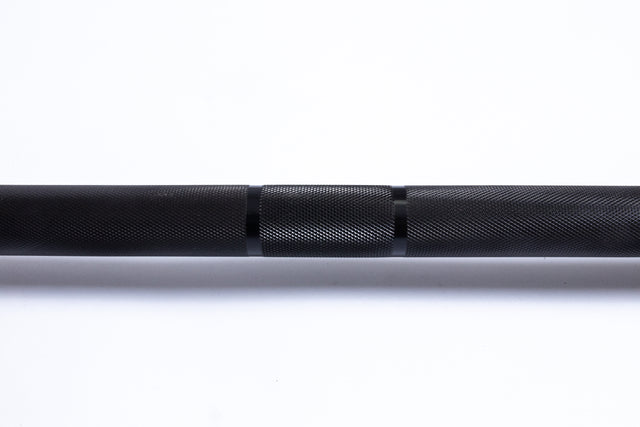 A close-up of the Bells of Steel Multi-Purpose Olympic Barbell – The Utility Bar, featuring a textured knurled grip. The black barbell, perfect for Olympic weightlifting, is set against a plain white background.