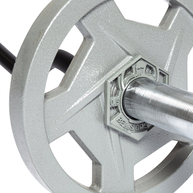 Close-up of a Bells of Steel Fractional Iron Plate - 0.5 LB on an Olympic barbell, displaying the silver cast iron plate labeled with "Bells of York" and "0.5". The plate is mounted through the center hole, showcasing the ribbed texture of the bar.