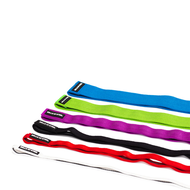 Five fabric non-slip resistance bands, ideal for mobility exercises or powerlifting, are displayed vertically on a white background. The 41" bands come in blue, green, purple, red, and black hues and prominently feature the "Bells of Steel" label.