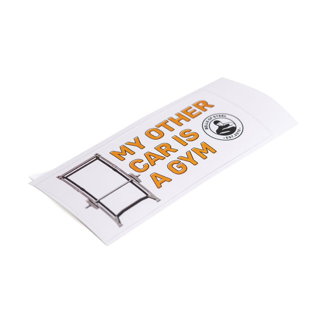 A rectangular, robust vinyl die-cut sticker from Bells of Steel showcases the striking orange text "MY OTHER CAR IS A GYM" with a ladder illustration next to it. On the right side, there is a circular logo. This unique design comes with free shipping!