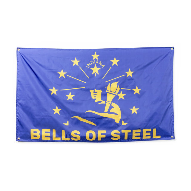 Introducing the Bells of Steel flag, an eye-catching addition to your gym decor. This vibrant blue flag prominently displays the words "BELLS OF STEEL" in yellow at the bottom. It features a unique design with a torch encircled by 13 yellow stars and "INDIANA" elegantly written above in yellow, making it a standout piece for any home gym flag collection.