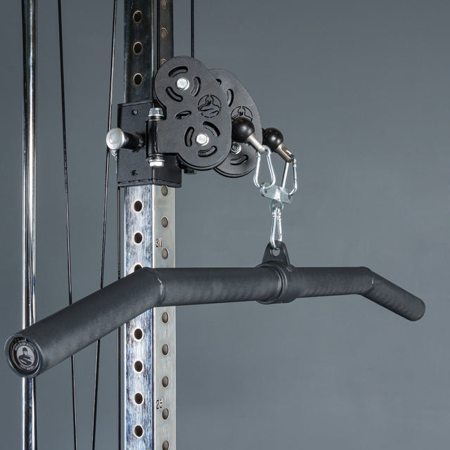 A close-up of the Bells of Steel Fat Bar - Lat Pulldown Bar, a black, angled cable machine attachment for improved grip strength, secured to a metal frame against a plain gray background.