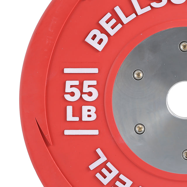 A close-up of a red LB Competition Bumper Plate displays "Bells of Steel" and "55 LB" in white letters. This training plate, designed for Olympic lifting enthusiasts, includes a central metal hub with four bolts and a circular hole.