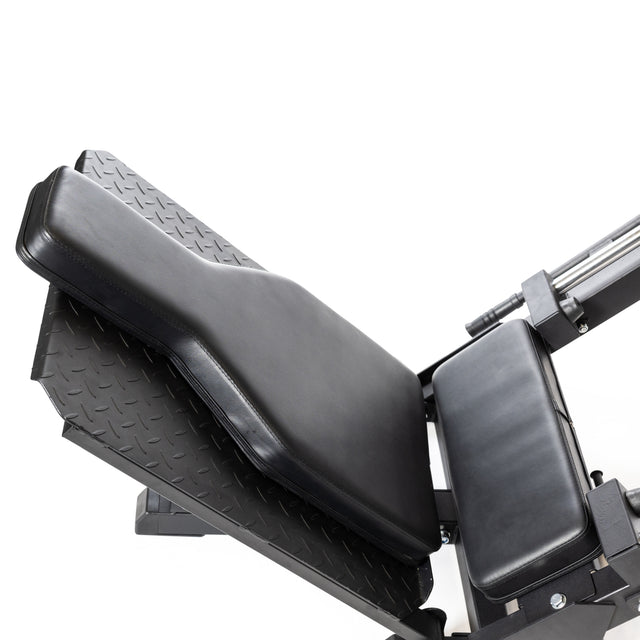 Close-up of the Bells of Steel Leg Press Hack Squat Machine, showcasing its black padded seat and foot platform against a white background. The sleek design with metallic components highlights its impressive capacity for an enhanced workout experience.