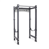 The Manticore Four Post Power Rack Builder by Bells of Steel, featuring 3" x 3" uprights with 1" holes for adjustable attachments and a pull-up bar, is perfect for home gyms. It includes safety straps and stands on a white background.