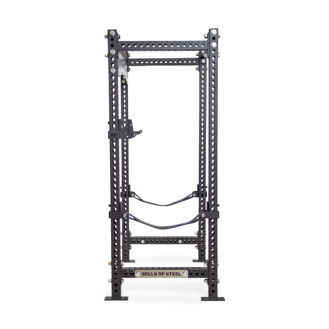 The Manticore Four Post Power Rack Builder by Bells of Steel is crafted from black steel and ideal for the home gym. It features 1" adjustable holes and modular components. Equipped with stabilizing bars, it showcases a logo at its base that reads "Bells of Steel," offering both strength and versatility.