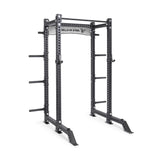 The Manticore Collegiate Power Rack Builder by Bells of Steel, featuring modular components and 1" holes for adjustable weight placement, showcases the brand on the top crossbar. It includes side pegs for weight storage and is set against a plain white background to fuel your fitness goals.