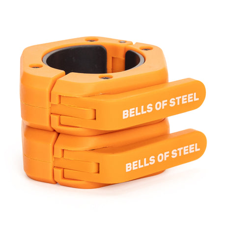Two bright orange Bells of Steel Magnetic Clamp Collars are stacked, each displaying the brand name in white on the locking lever—ideal for securely clamping barbells or weight plates.