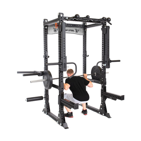 male model performing squats in Manticore Flat Foot Power Rack PREBUILT with attachments 