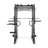 Against a plain white backdrop, the Manticore Flat Foot Power Rack Builder (3" x 3", 1" Holes) is prominently displayed, featuring various attachments like a pull-up bar and dip handles. The brand name "Bells of Steel" is proudly emblazoned across the top crossbar, showcasing its open ecosystem flexibility.
